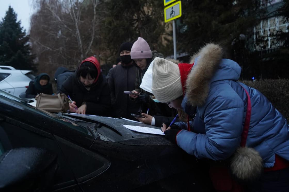 Алматинцы пишут заявления прямо на капотах машин