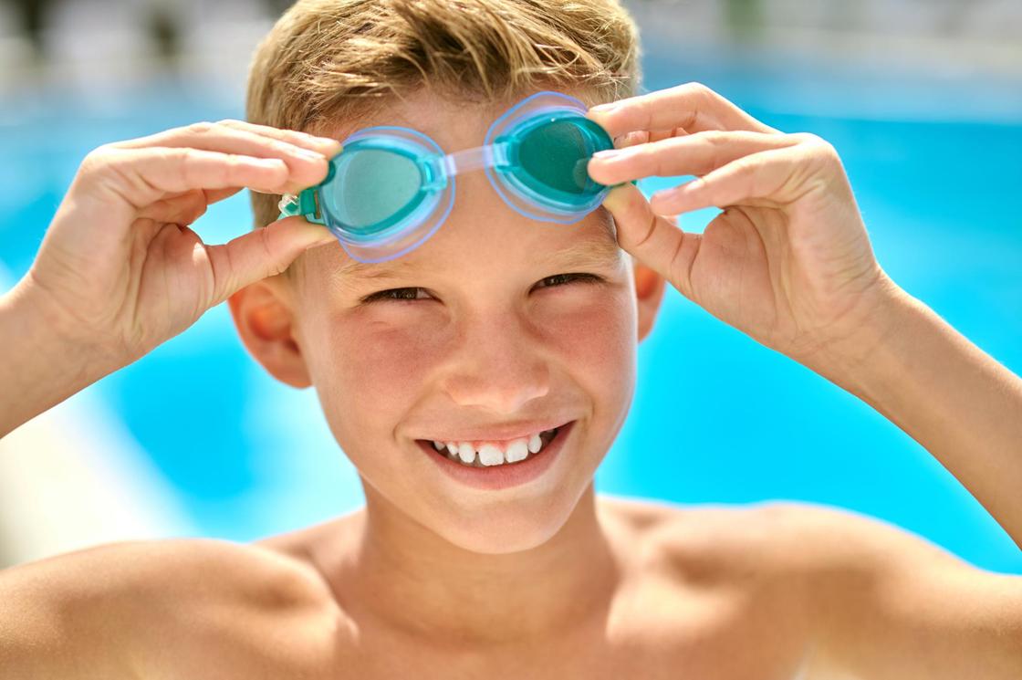 Мальчик надевает очки для плавания