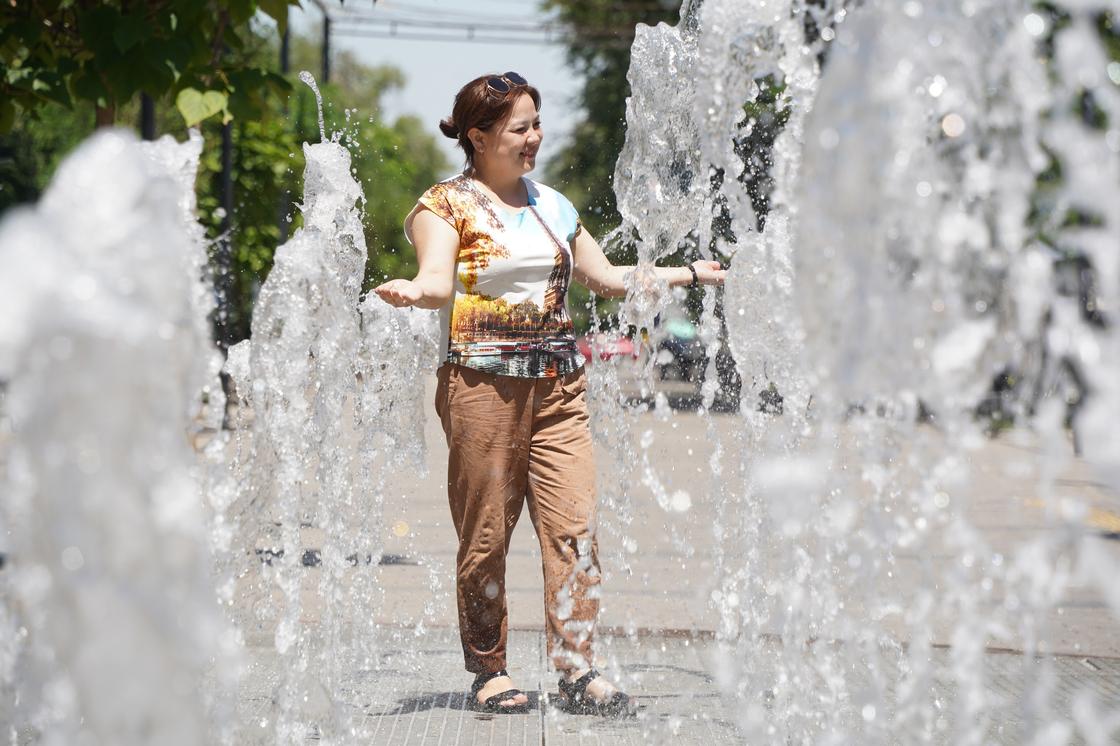 Женщина стоит в пешеходном фонтане