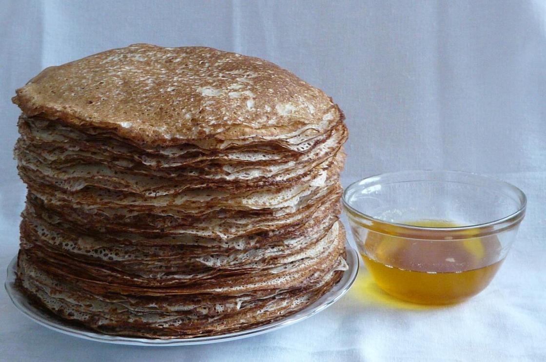 Высокая стопка блинов и плошка с медом Высокая стопка блинов и плошка с медом