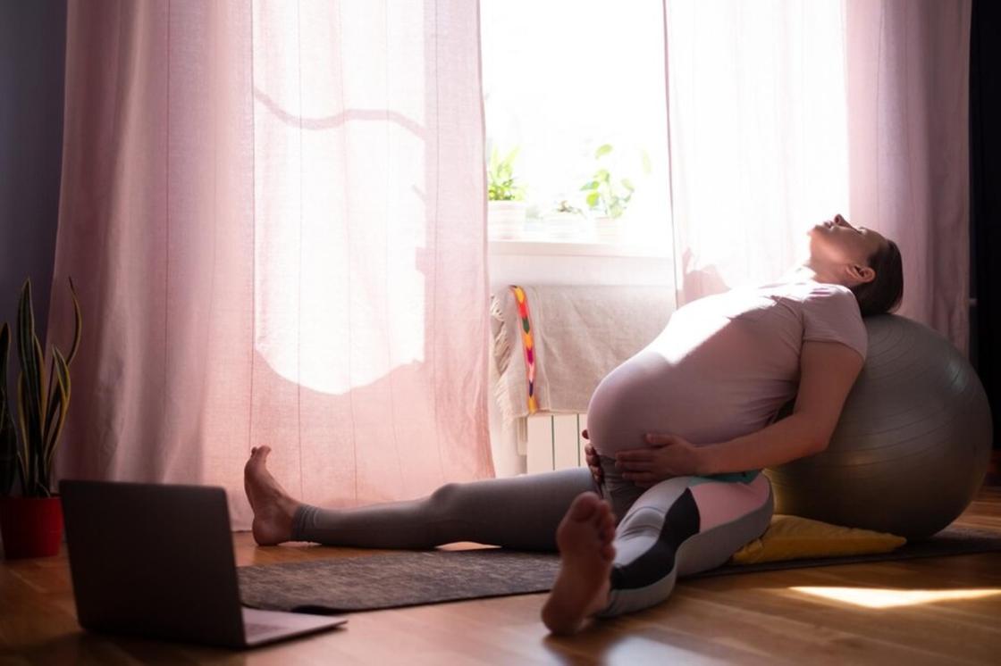 Беременная женщина выполняет упражнение на расслабление
