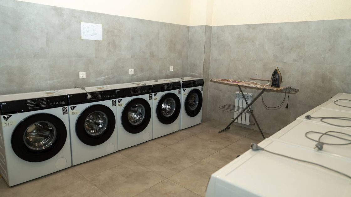 Комната со стиральными машинами и гладильной доской