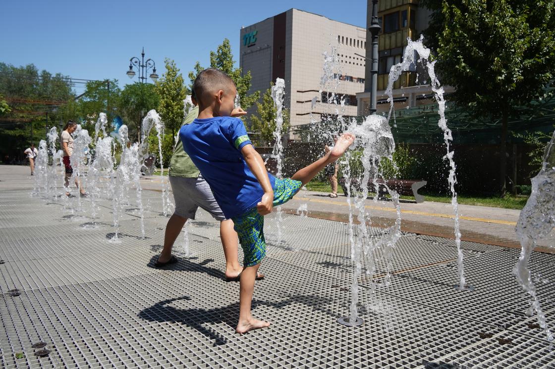 Мальчики играют на пешеходном фонтане