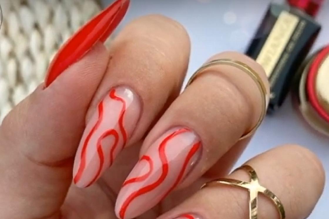 Длинные овальные ногти с красными волнами на нюдовой основе