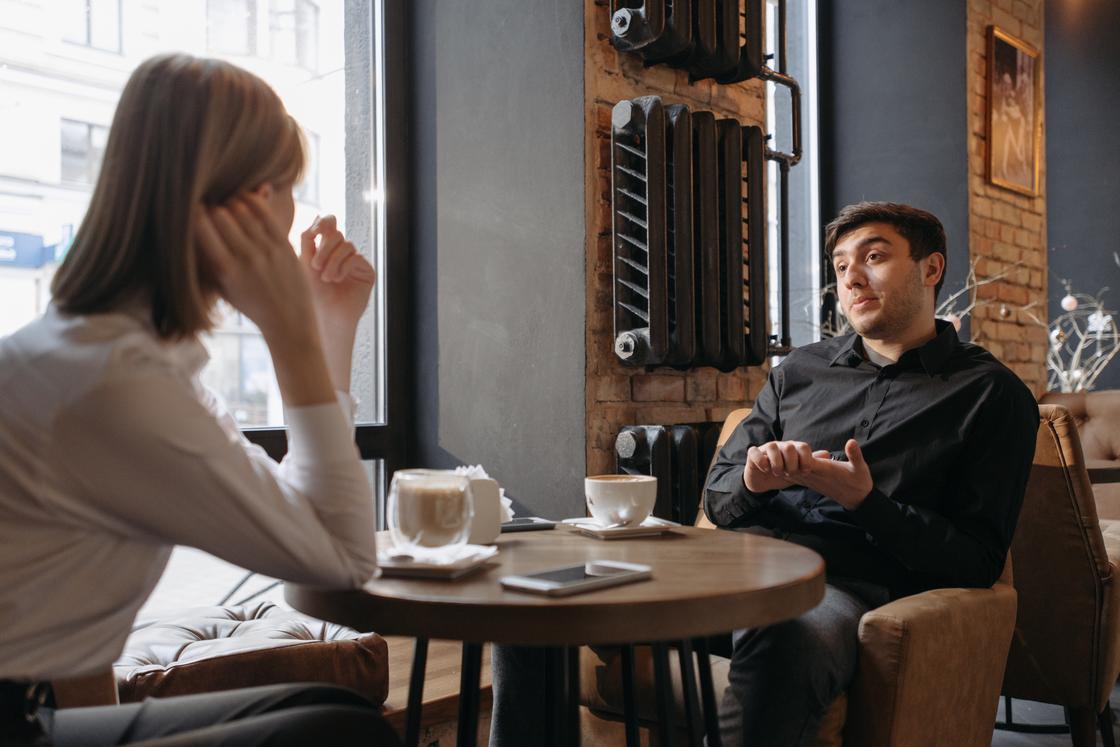 Парень и девушка общаются за столиком в кафе