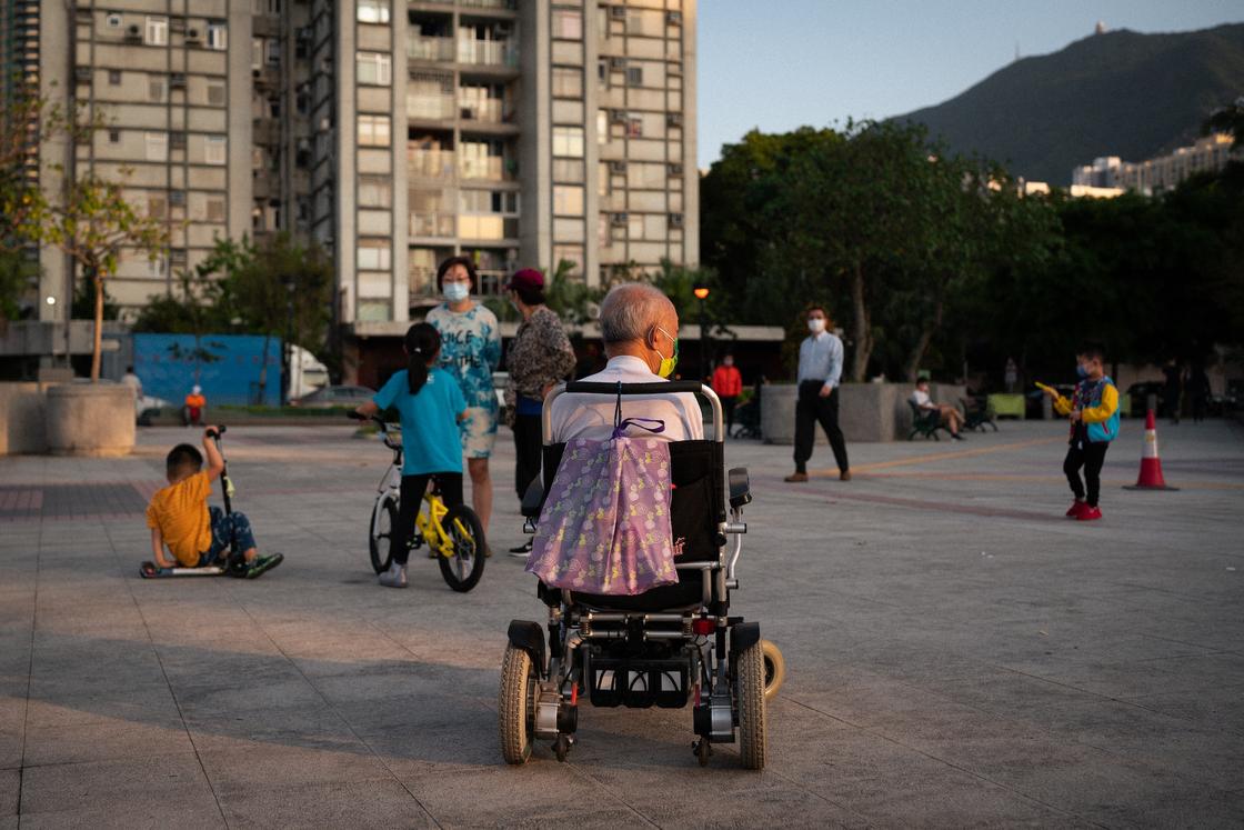 Мужчина в инвалидном кресле на детской площадке