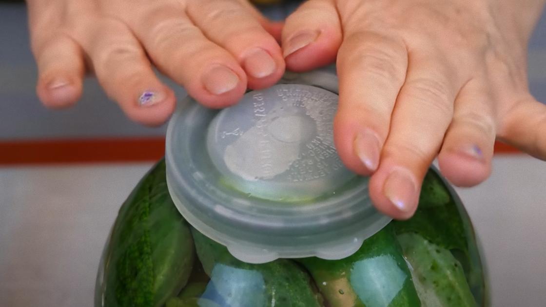 Банку с огурцами закрывают капроновой крышкой