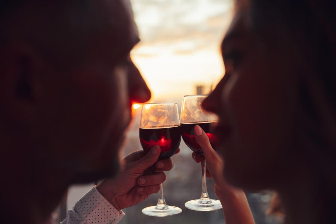 Парень и девушка держат бокалы с вином