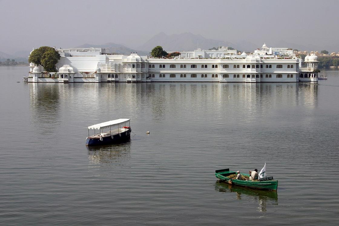 Лодки плывут к дворцу Taj Lake из белого мрамора