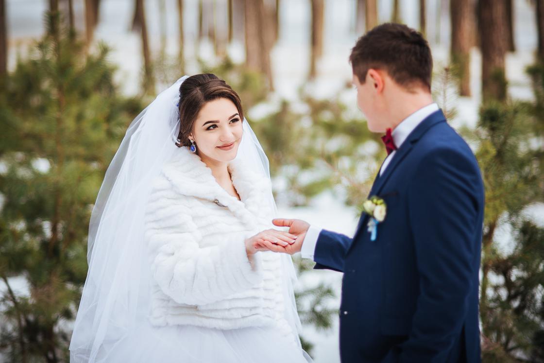 Жених и невеста на фоне зимнего пейзажа