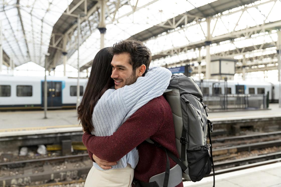 Влюбленная пара обнимается на вокзале