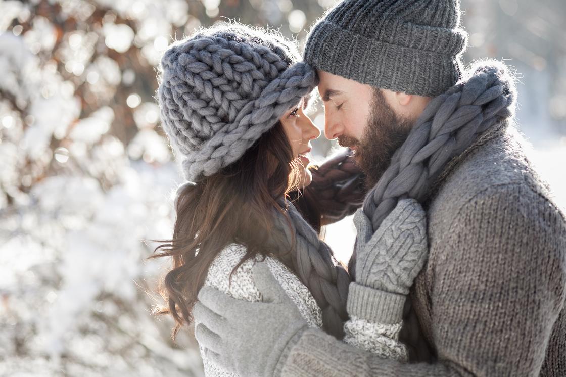 Влюбленная пара обнимается на фоне зимней природы