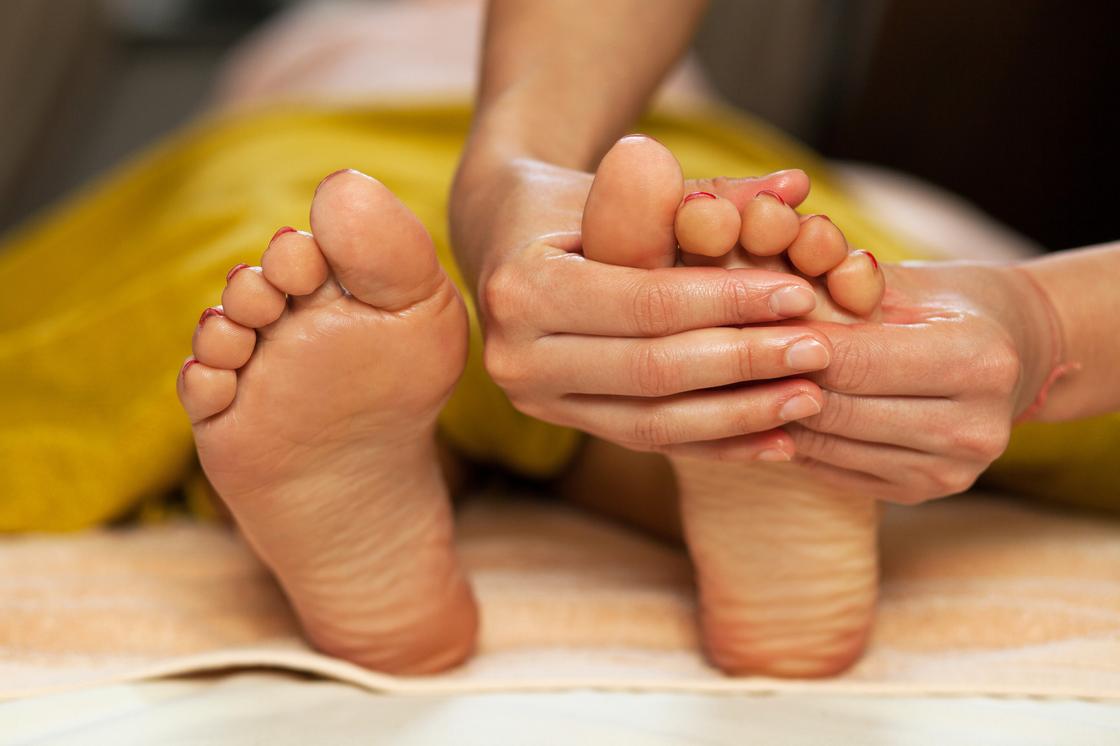 Женщине делают массаж ног