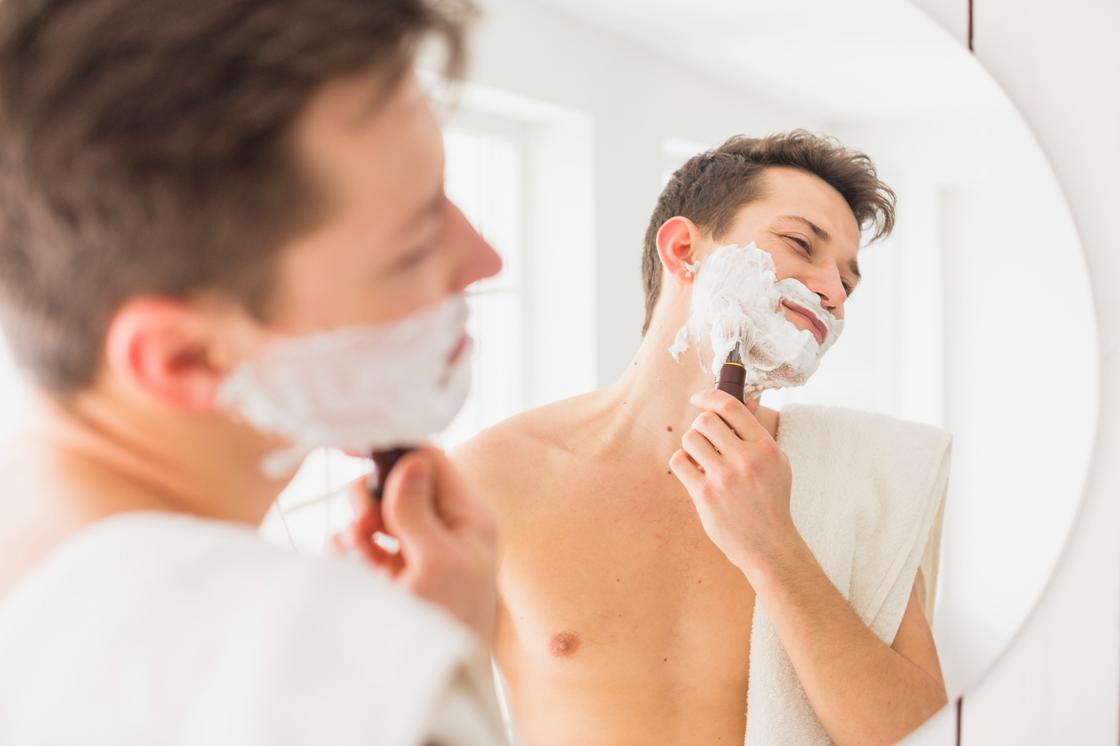 Перед бритьем. Мужчина бреется в ванной. Бреящийся или бреющийся мужчина. Мужской уход. Бриться с вечера.
