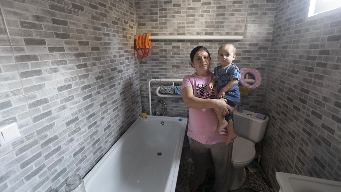 Беременная женщина стоит с ребенком в ванной
