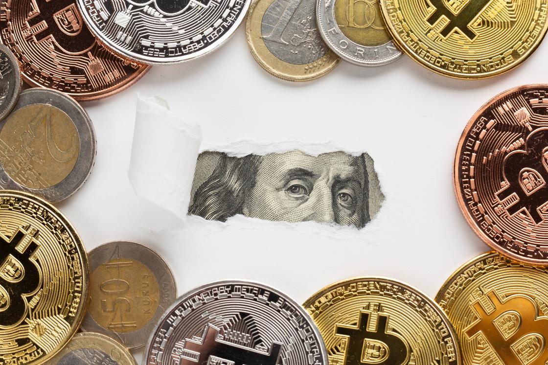 Монеты и биткойны, в центре видна часть изображения Бенджамина Франклина