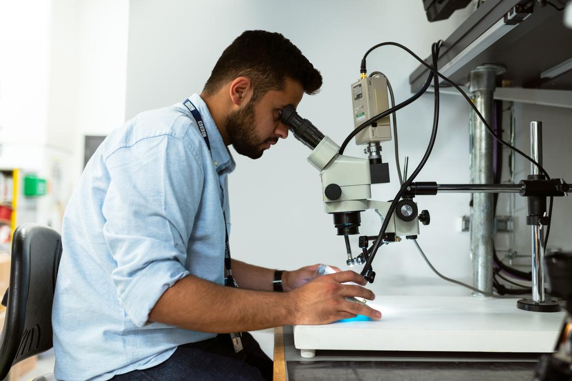Мужчина работает с микроскопом