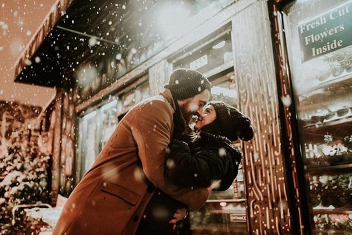 Влюбленные парень и девушка на улице под снегом