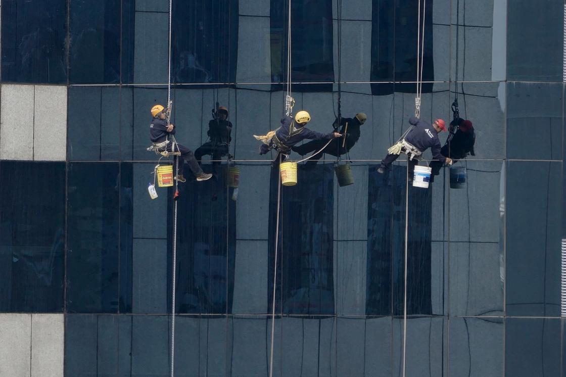 Мужчины на страховке моют панорамные окна