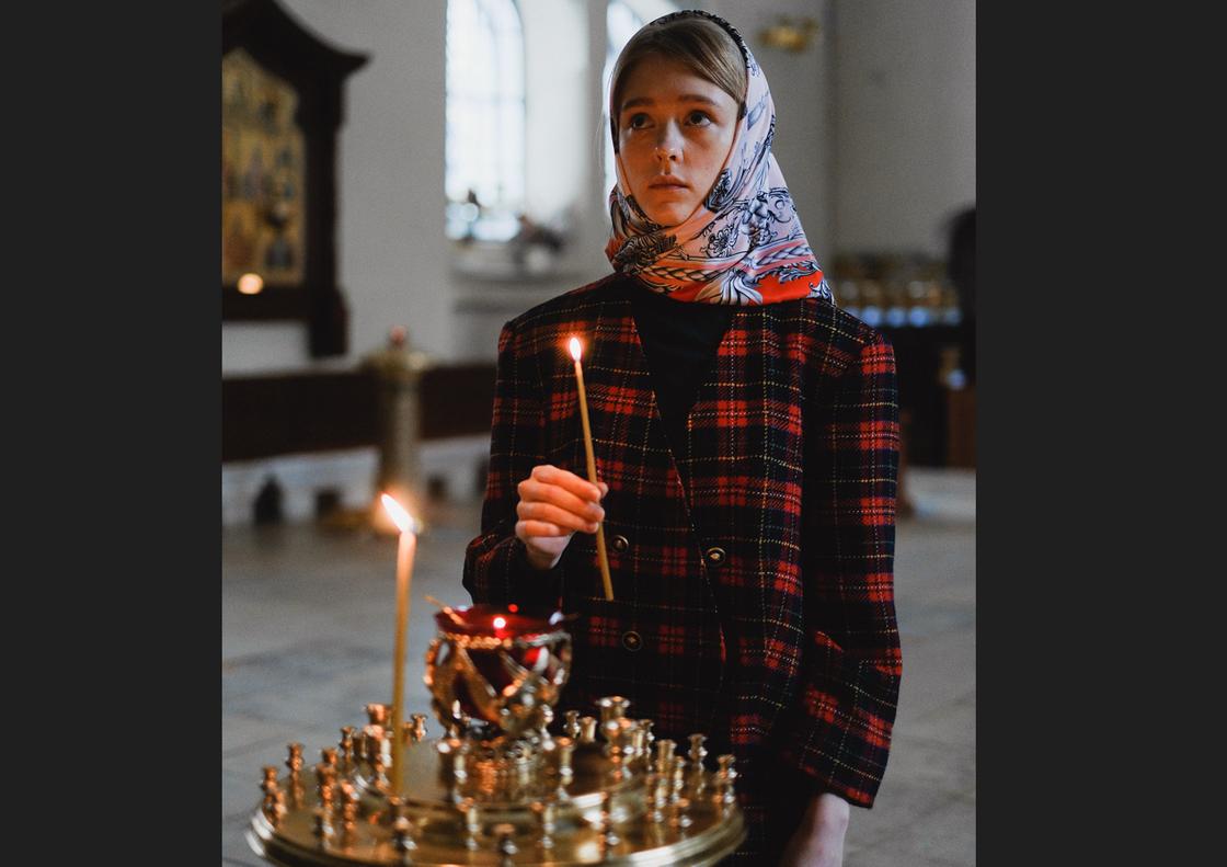 Девушка со свечой в церкви