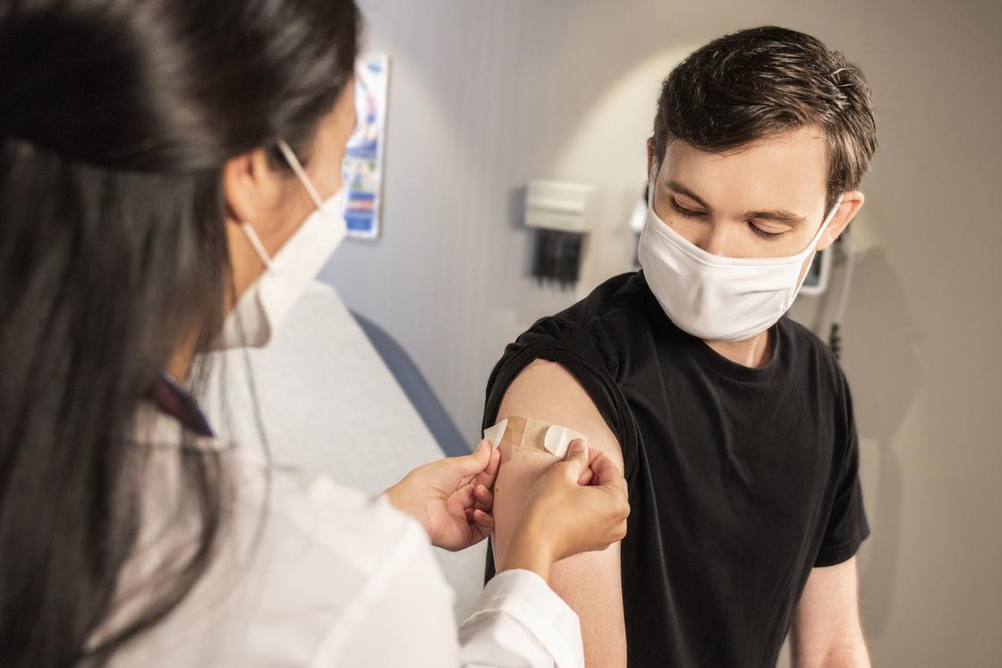 Мужчина вакцинируется в кабинете врача