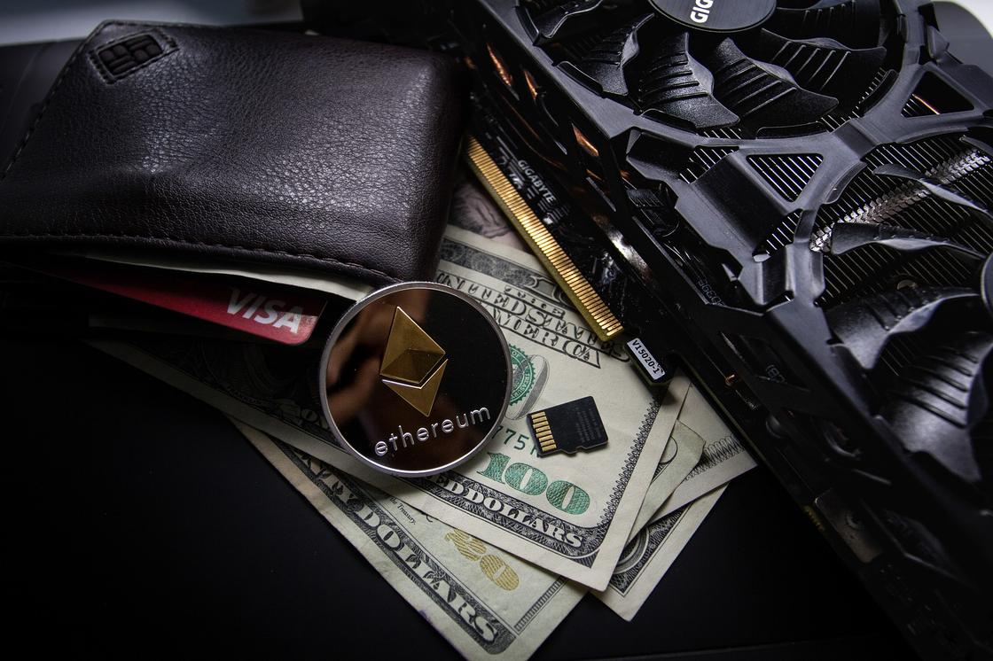 Монета Ethereum лежит на долларовых купюрах и кошельке