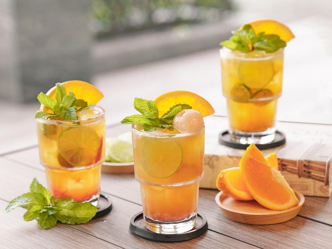 Напитки с апельсином и личи, налитые в стаканы