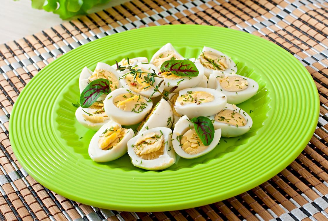 Вареные перепелиные яйца на зеленой тарелке