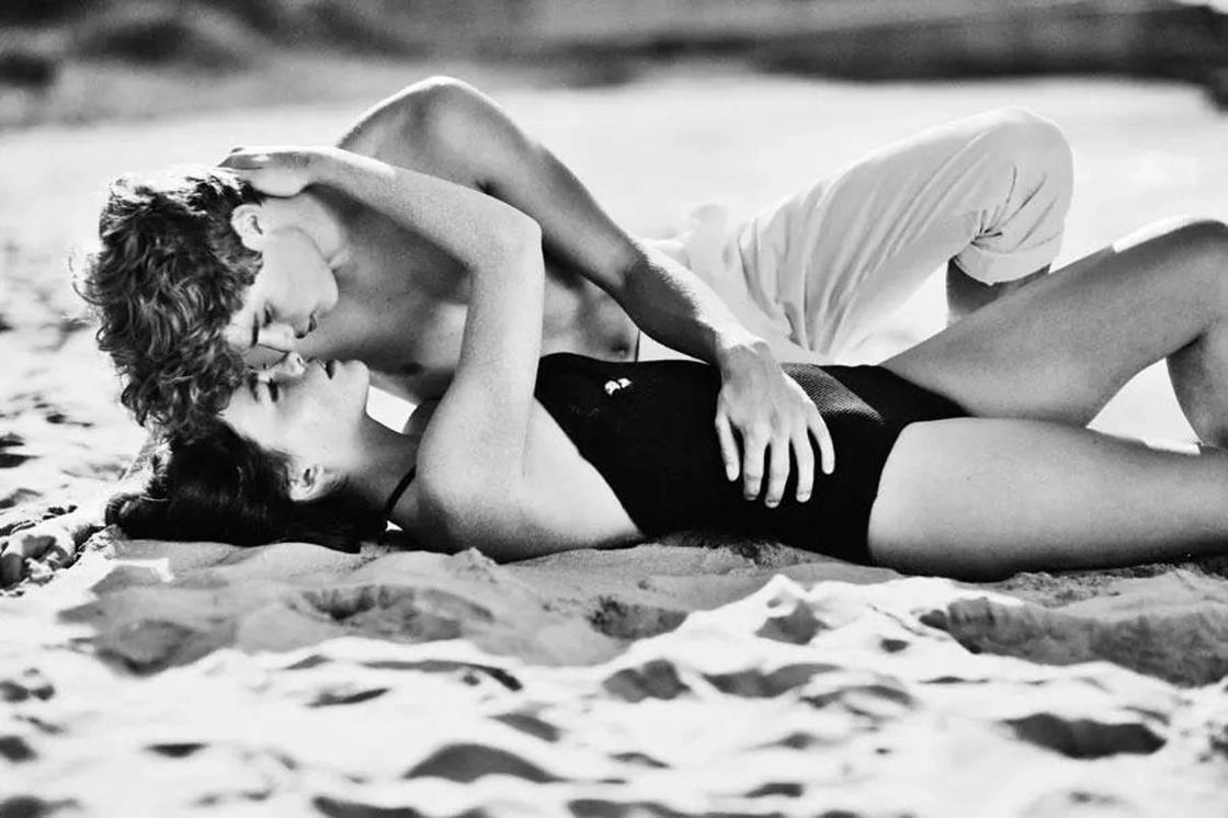 Парень целует девушку на пляже