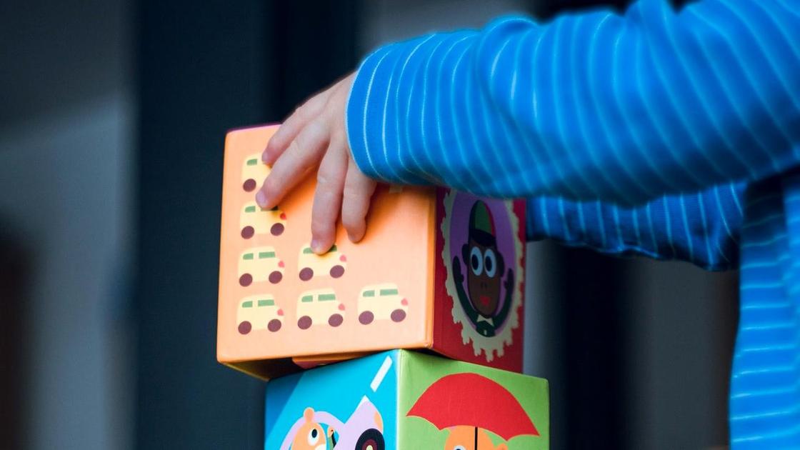 Ребенок строит башню из игрушечных кубиков