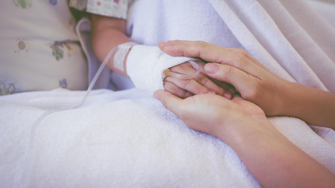 Родитель держит ребенка за руку в больнице