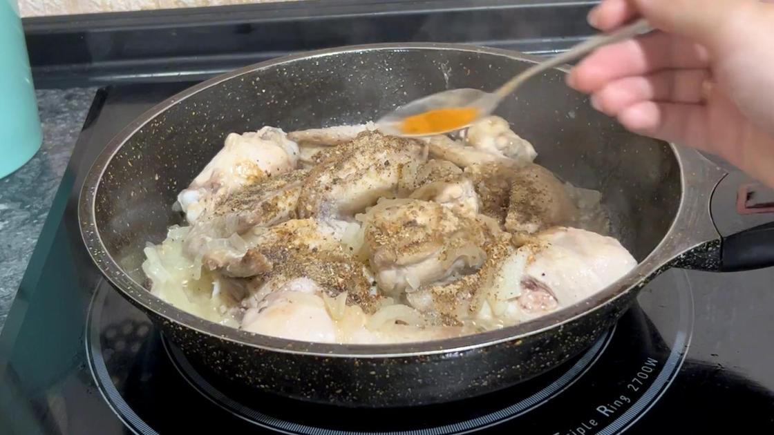 В сковороду к куриным крыльям добавляют черный молотый перец, паприку