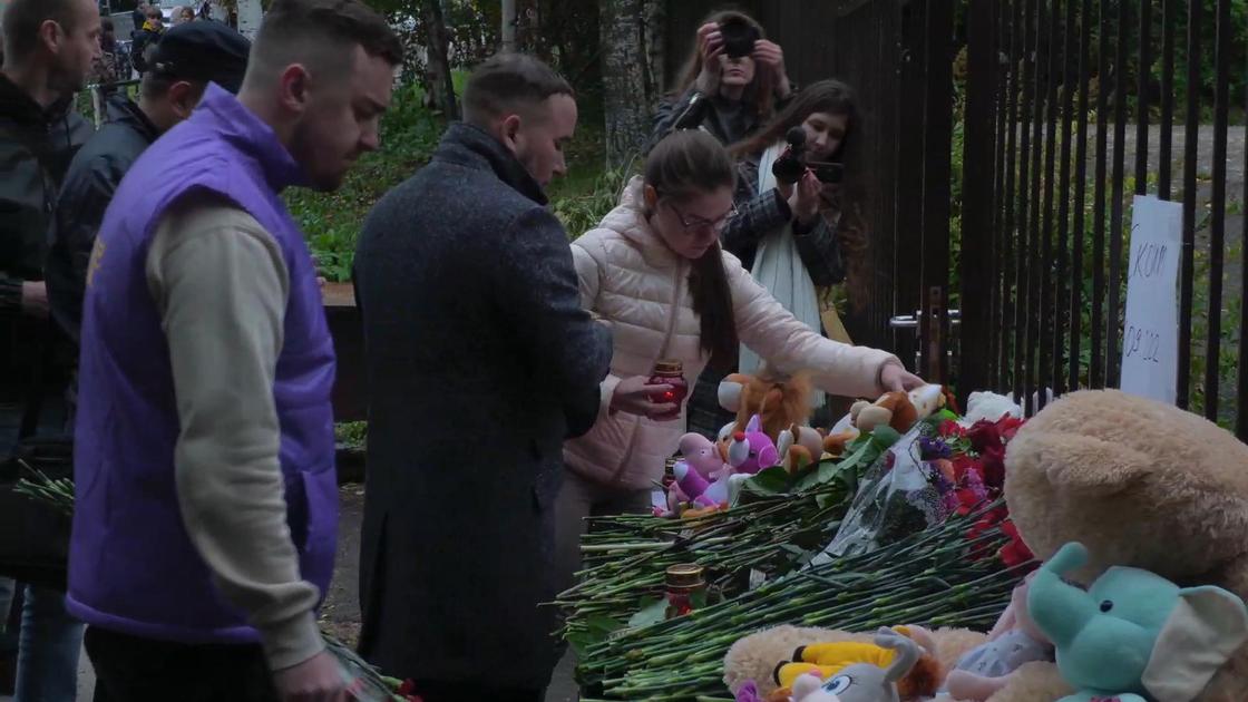Люди несут цветы и игрушки к школе в Ижевске