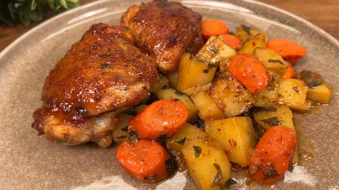 Запеченное бедро курицы с картофелем и морковью на тарелке