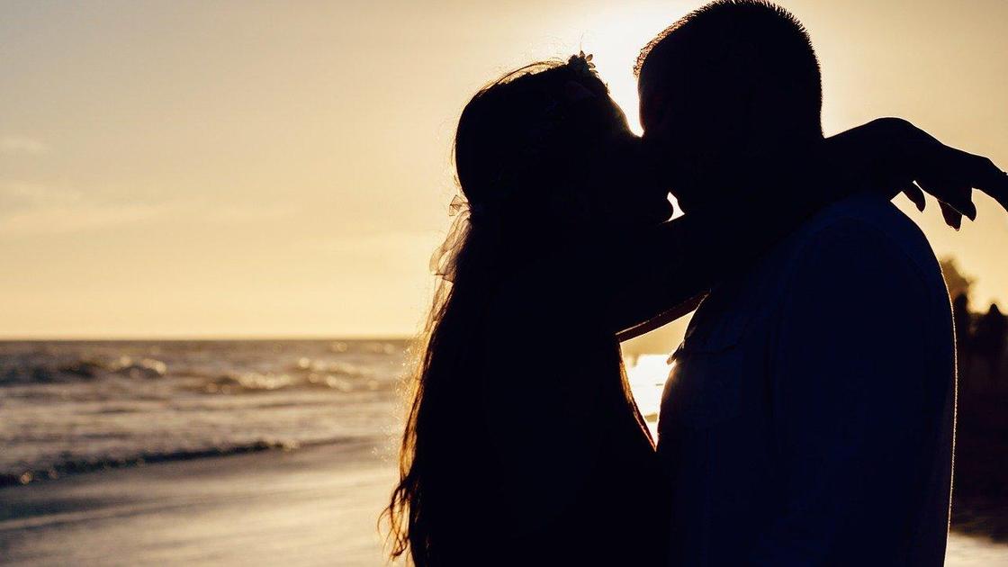Пара целуется на берегу