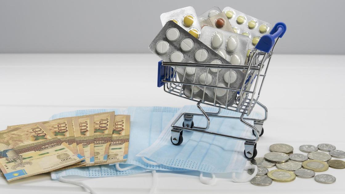 Лекарства в лежат в миниатюрной тележке для покупок