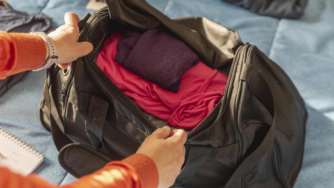 Мужчина складывает вещи в сумку