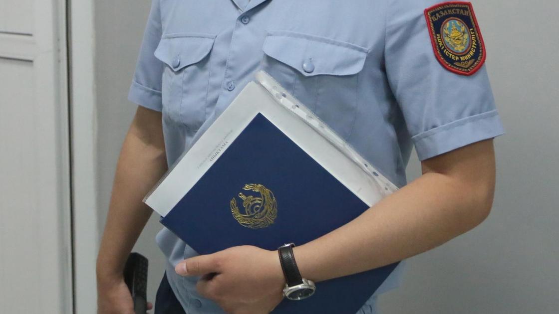 Сотрудник полиции держит в руках синюю папку