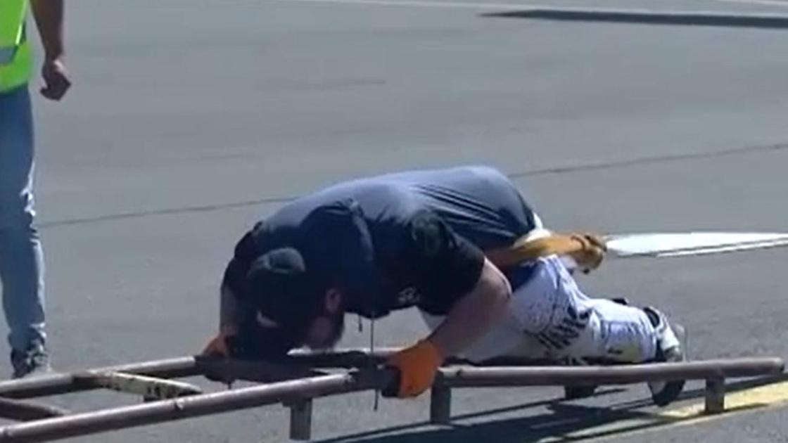 Казахстанский тяжелоатлет Алмат Джуманов пытается сдвинуть с места самолет