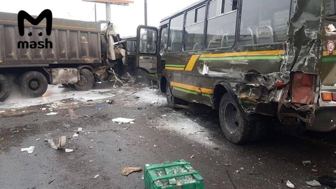 Поврежденные военный автобус и самосвал стоят на дороге Поврежденные военный автобус и самосвал стоят на дороге