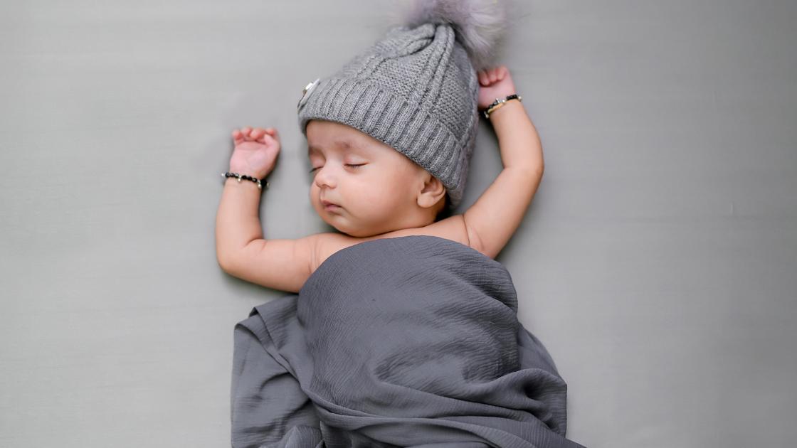 Маленький ребенок в шапочке спит