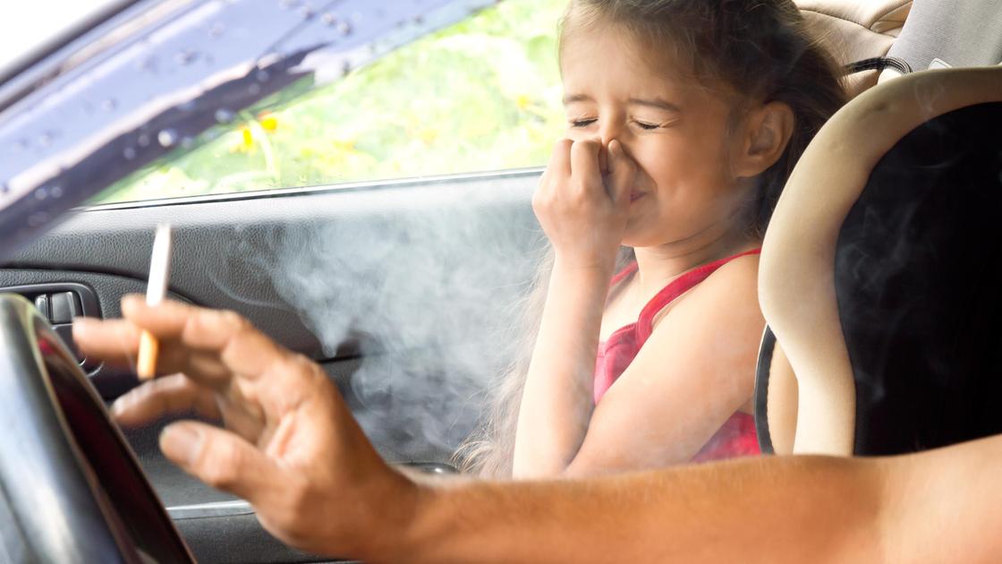 Водитель курит в машине при ребенке