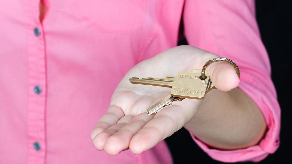 женщина держит в руке ключи от дома