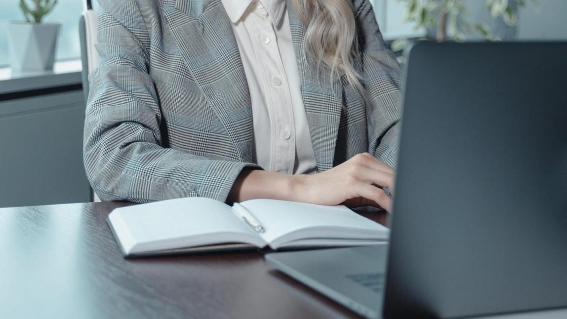 Женщина сидит за ноутбуком в офисе