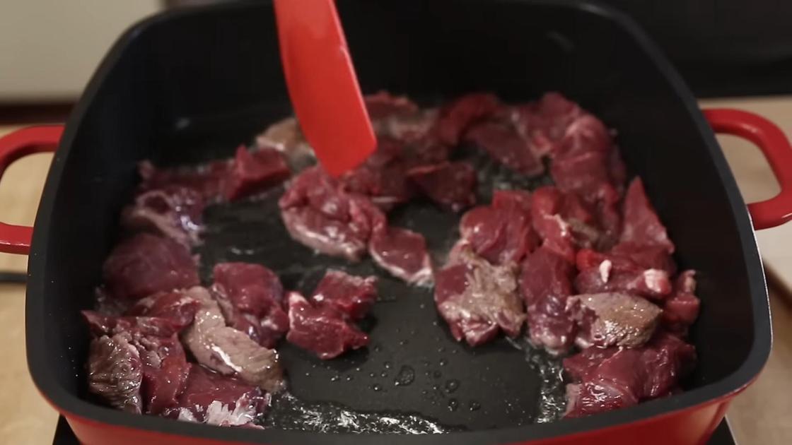 Кусочки говядины обжаривают на сковороде перемешивая кулинарной лопаткой