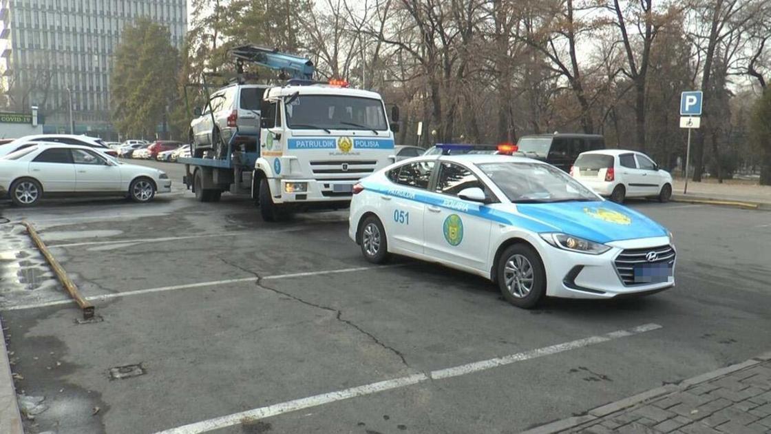 Машина и эвакуатор полиции на парковке в Алматы