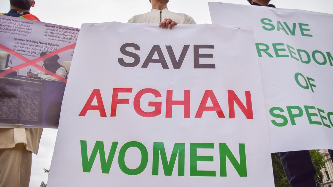 Протестующие в Лондоне держат плакат "Спасите афганских женщин"