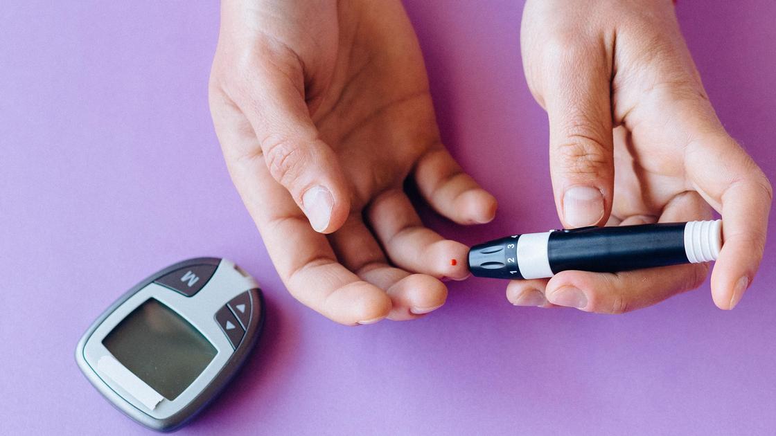 Человек измеряет сахар в крови с помощью глюкометра