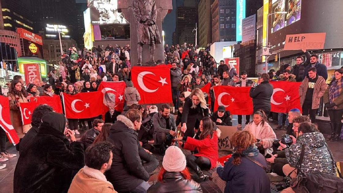 Люди с турецкими флагами стоят на улице