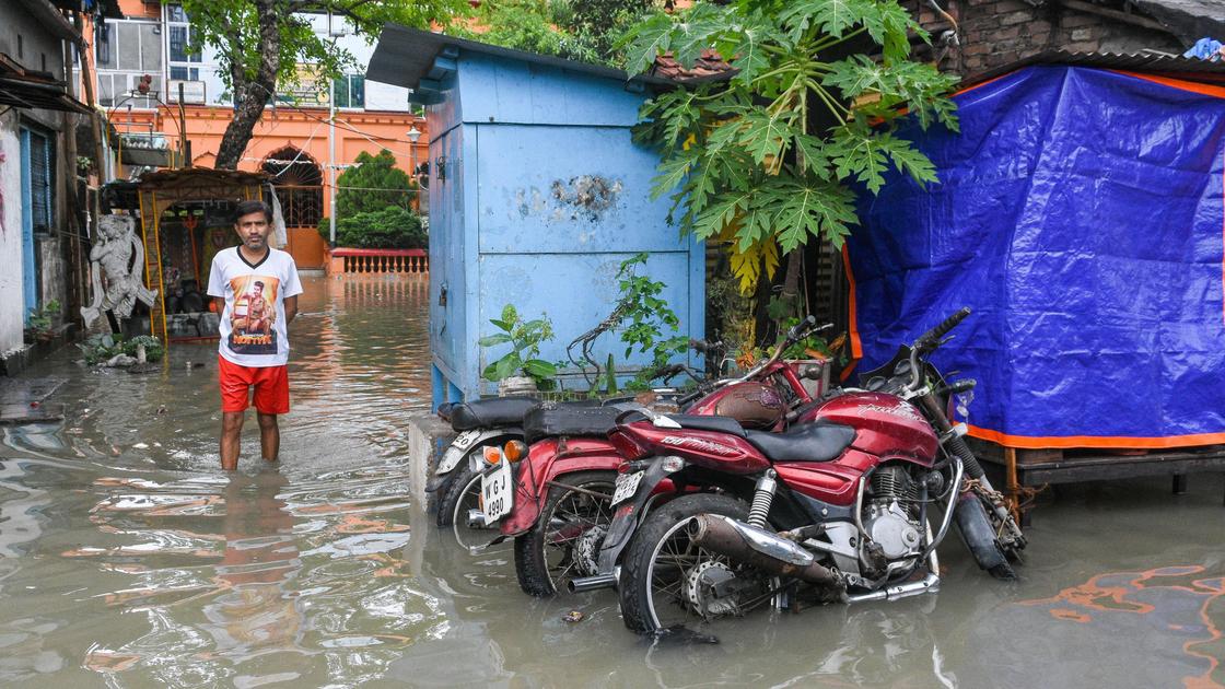 Мужчина около затопленных мотоциклов в Индии